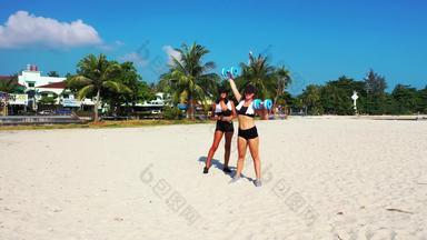 年轻的微笑女士们假期有趣的海滩清洁白色沙子蓝色的背景